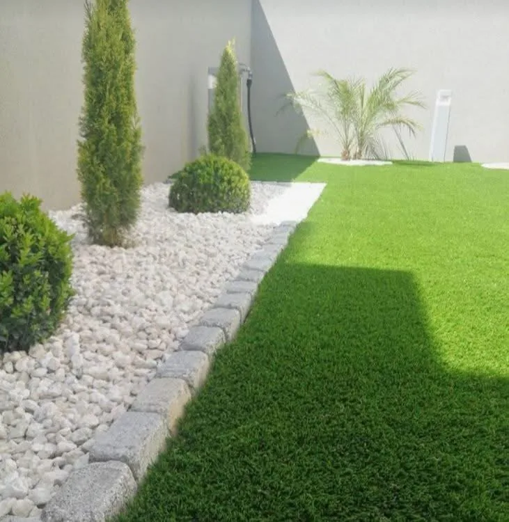 Jardín residencial limpio con césped y piedra decorativa